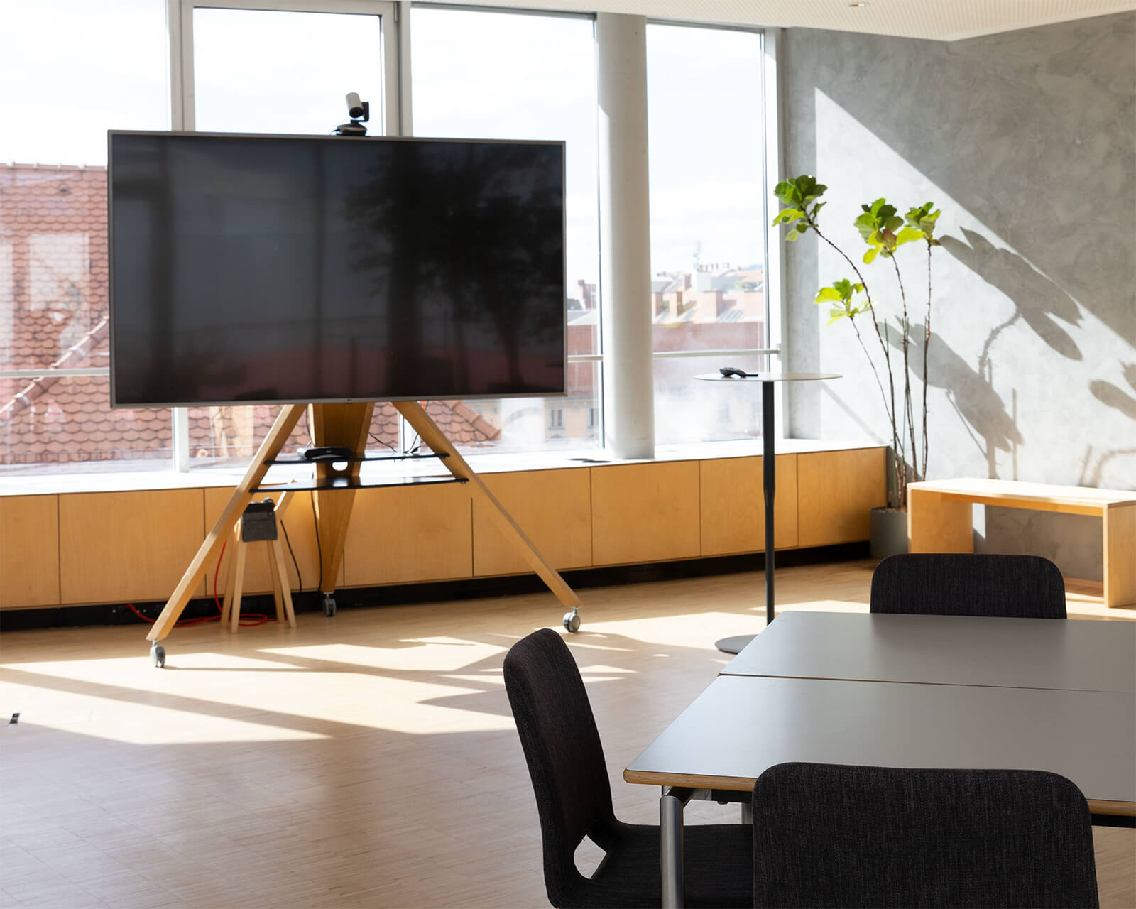 Workshop-Setup im Level mit großem Bildschirm, Tischen und Sesseln